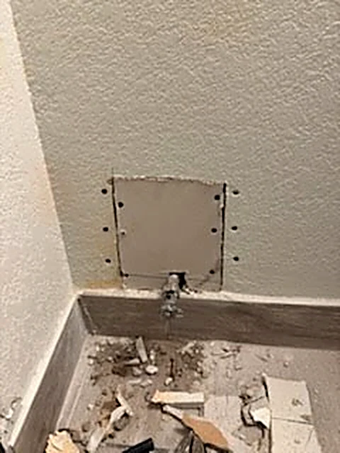 Wall repair before finishing, with exposed patch and debris